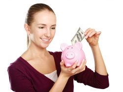young woman putting money into piggy bank