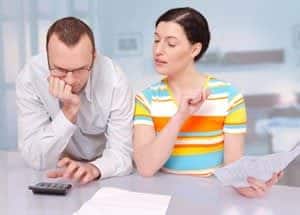 Man and women reviewing papers and calculator