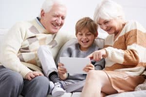 Older grandparents and young grandson surfing the internet together