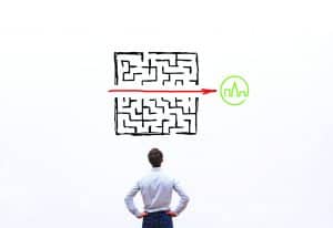 A man looking at a maze with an arrow in the middle pointing to our logo