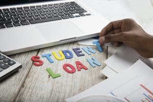 Hand arrange wood letters as student Loan word