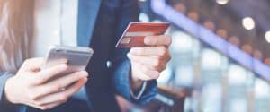 Woman holding credit card and smart phone