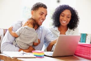 Parents With Baby Working In Office At Home
