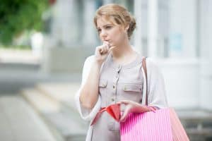 Woman looking worried holding shopping bag