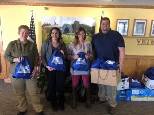 Presentation of drawstring bags filled with donation items for veterans