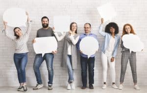 Diverse group of people holding up white thought bubbles