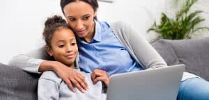 African American woman with young daughter looking at a laptop together
