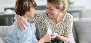 Mother giving young teenage son cash from wallet as allowance