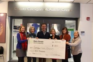 Group of people holding a big check donation to Framingham State University for $1,000