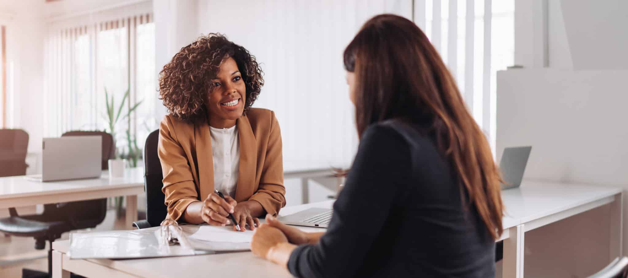 Woman interviewing another woman sitting at a desk