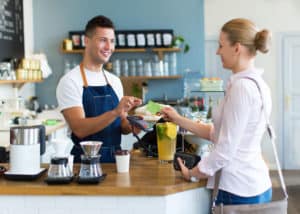 Woman using Main Street Bank debit card at a local coffee shop