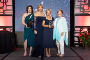 Main Street Bank executives pose with Roxanne Emmerich, holding their Banky award.