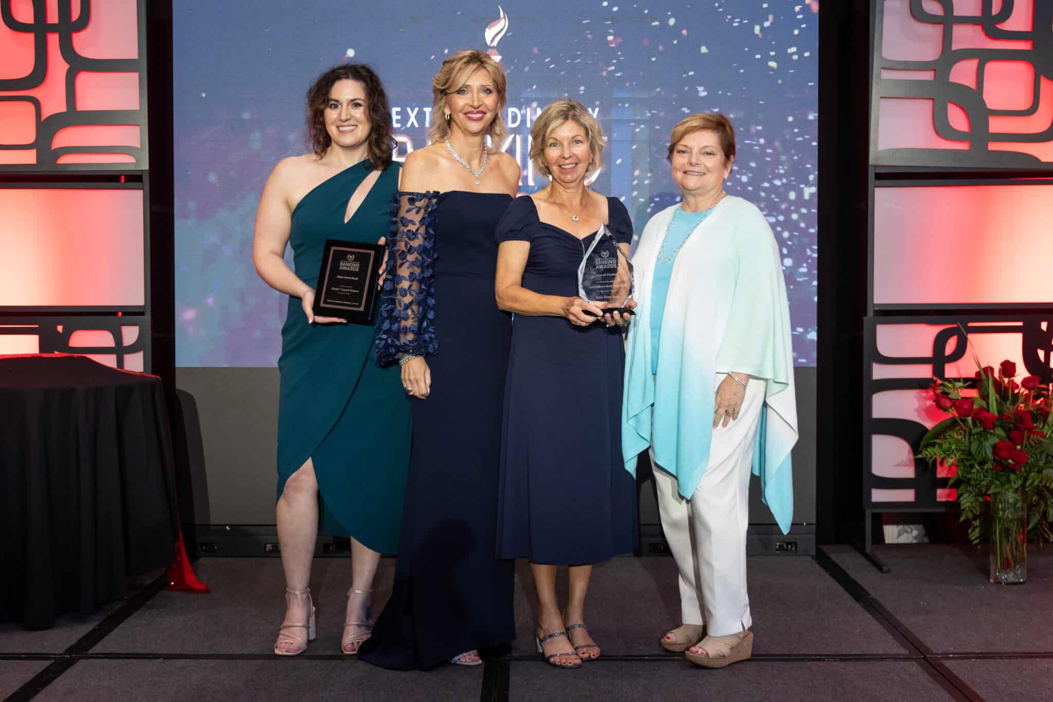 Main Street Bank executives pose with Roxanne Emmerich, holding their Banky award. 