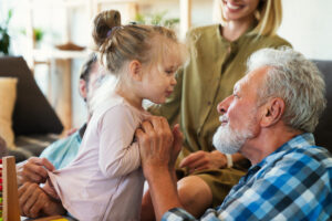 Cheerful multi-generation family having fun while spending time together at home. People happiness concept. Related to family preparing trust account for future.